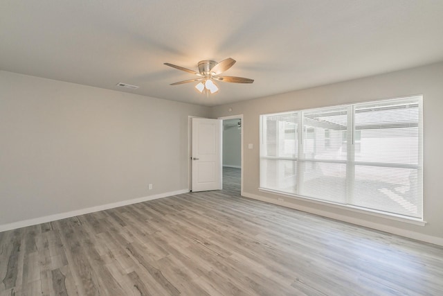 unfurnished room featuring light wood-style flooring, a ceiling fan, and baseboards