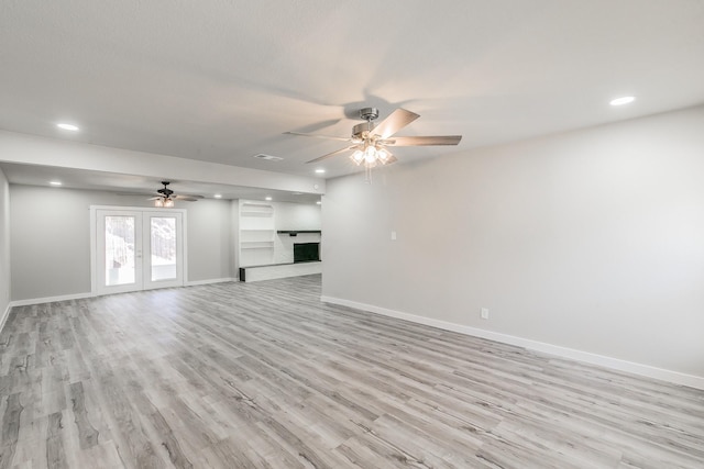 unfurnished living room featuring light wood-style flooring, baseboards, and ceiling fan