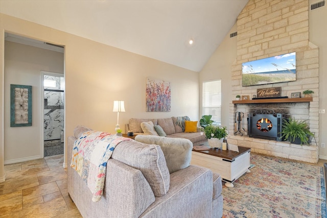 living area featuring baseboards, visible vents, high vaulted ceiling, stone finish floor, and a large fireplace