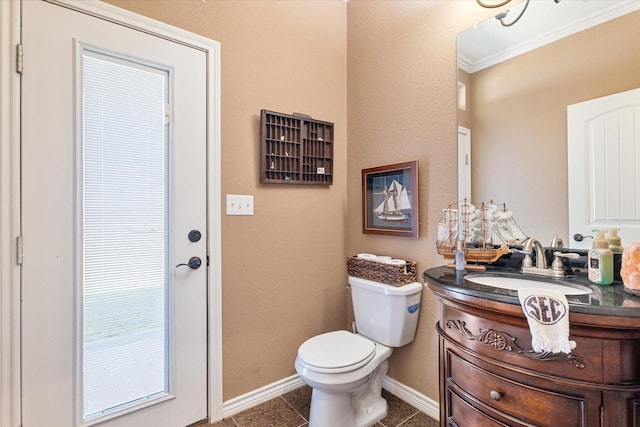 half bathroom with tile patterned flooring, baseboards, toilet, ornamental molding, and vanity