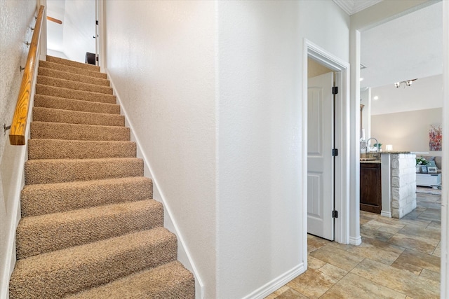 stairway with stone finish floor, a textured wall, and baseboards