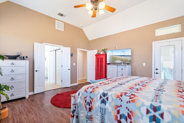 bedroom with lofted ceiling, wood finished floors, visible vents, and baseboards