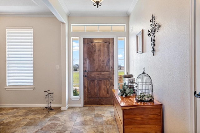 foyer entrance featuring stone finish flooring, baseboards, and crown molding