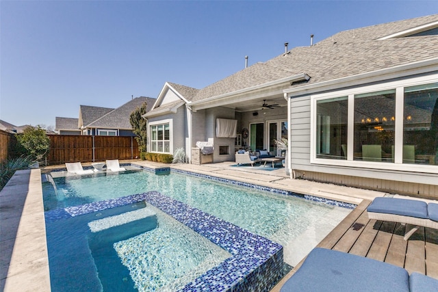 view of pool with a wooden deck, a fenced backyard, a ceiling fan, and a pool with connected hot tub