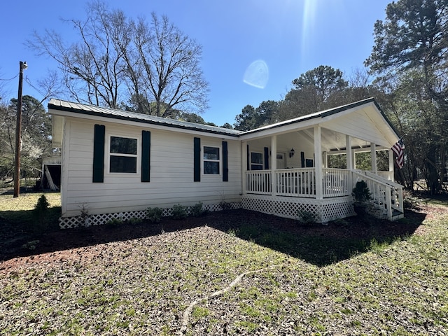 exterior space featuring covered porch and metal roof