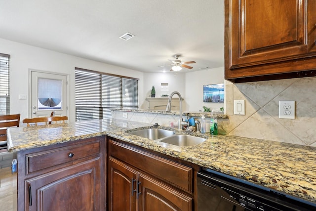 kitchen with visible vents, a sink, tasteful backsplash, light stone countertops, and dishwasher