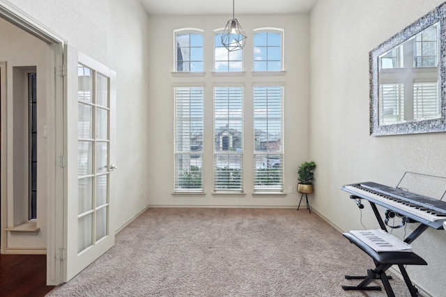 living area featuring a notable chandelier, carpet flooring, and a healthy amount of sunlight