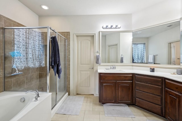 bathroom with a garden tub, vanity, a shower stall, and tile patterned flooring