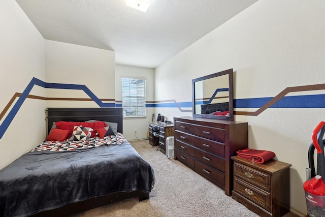 bedroom with light colored carpet and a textured ceiling