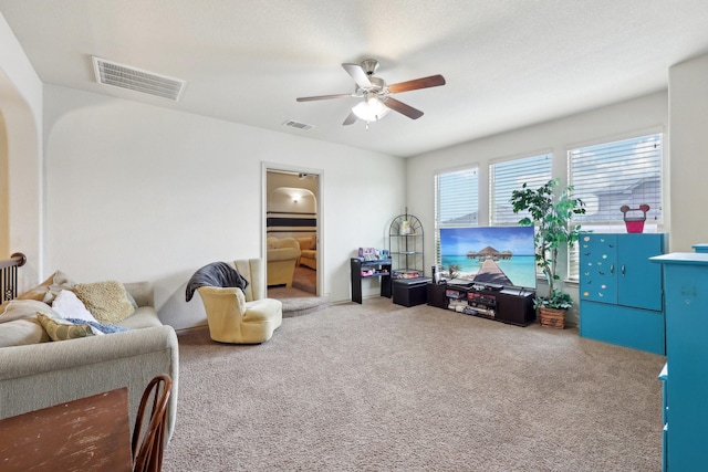 living area with carpet flooring, a ceiling fan, and visible vents