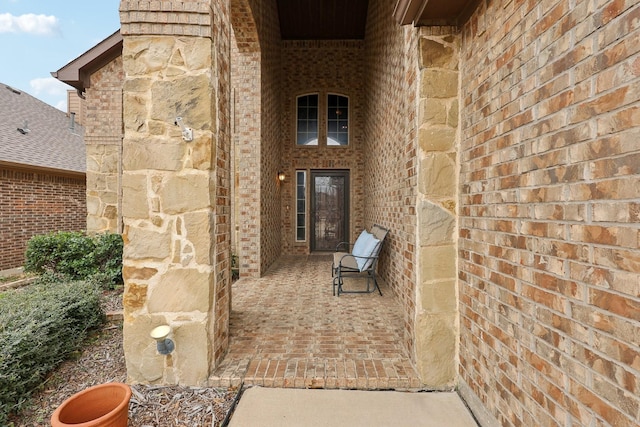 entrance to property featuring brick siding