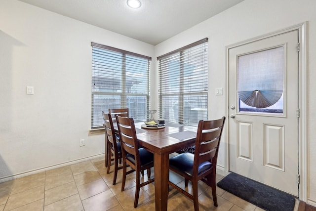 dining room with baseboards and light tile patterned flooring