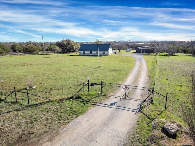 view of road with a gate, a rural view, and driveway