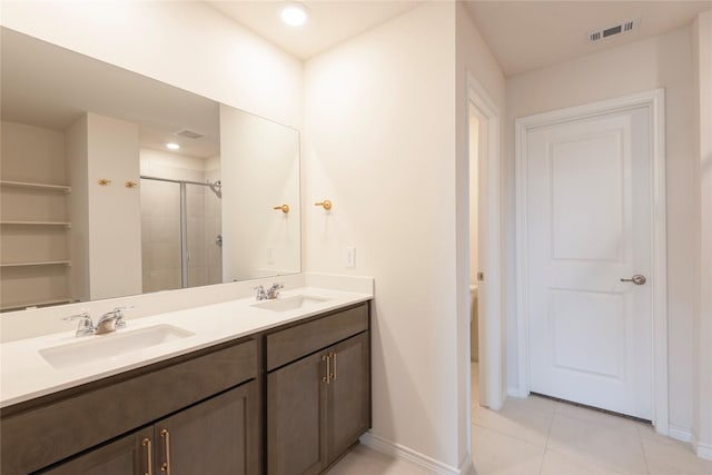 full bath featuring double vanity, visible vents, a stall shower, and a sink