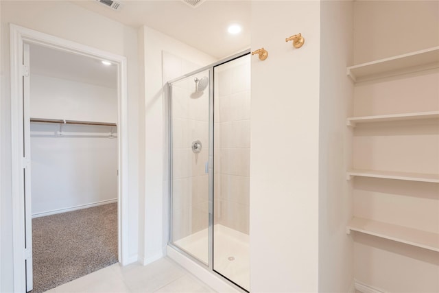 full bathroom with tile patterned floors, visible vents, a shower stall, baseboards, and a spacious closet