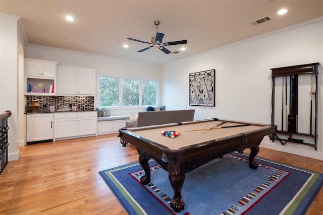 rec room featuring visible vents, ornamental molding, and light wood finished floors