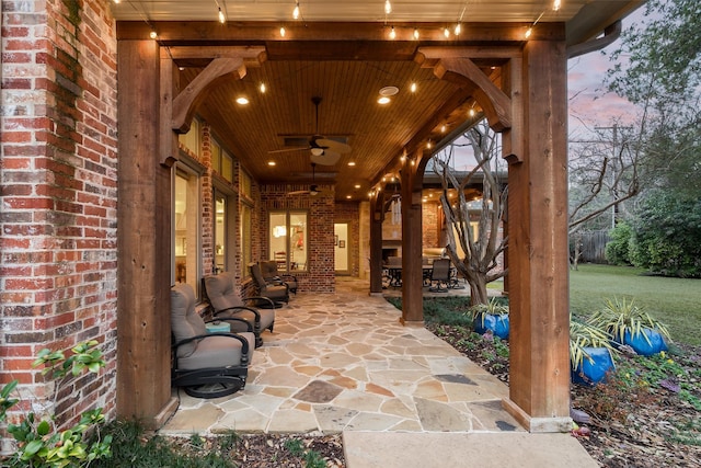 patio terrace at dusk featuring ceiling fan