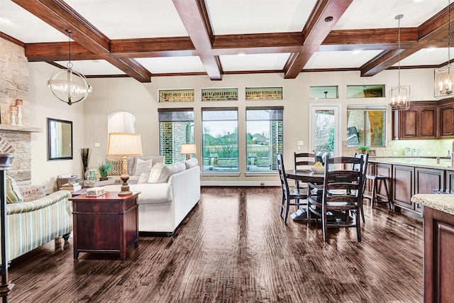 living room featuring beam ceiling, a notable chandelier, and dark wood finished floors