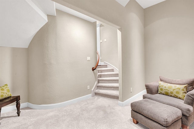 living area with stairway, baseboards, and carpet