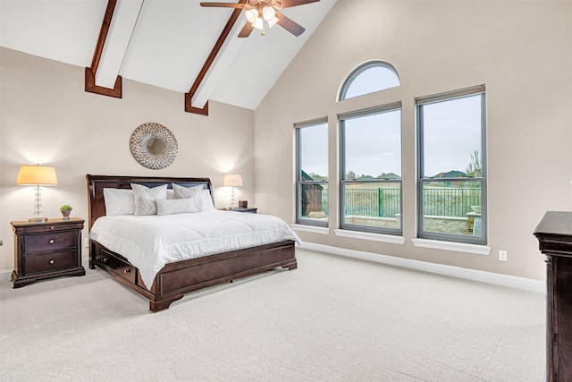 carpeted bedroom with beam ceiling, high vaulted ceiling, baseboards, and a ceiling fan