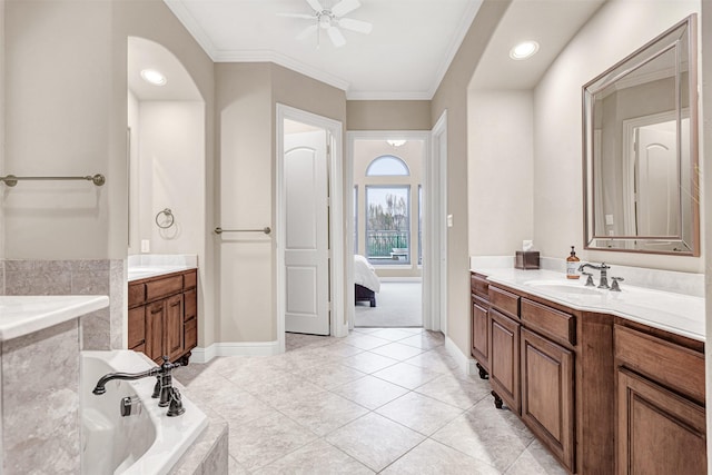 ensuite bathroom with tile patterned floors, two vanities, a sink, tiled bath, and crown molding