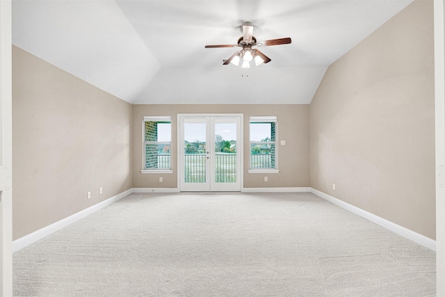 spare room with baseboards, lofted ceiling, light carpet, and a ceiling fan