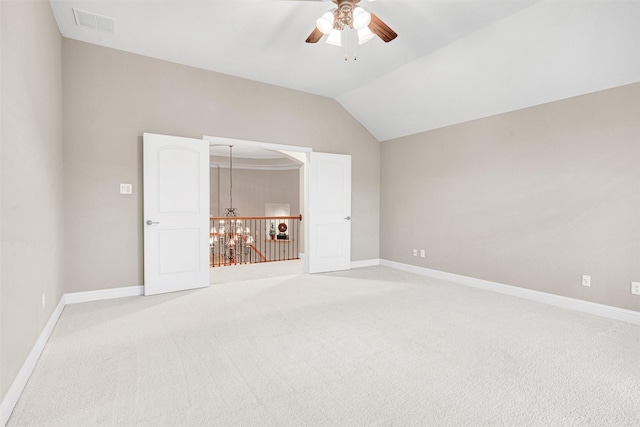 unfurnished bedroom featuring light colored carpet, baseboards, and vaulted ceiling