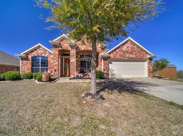 view of front facade with driveway, brick siding, and an attached garage