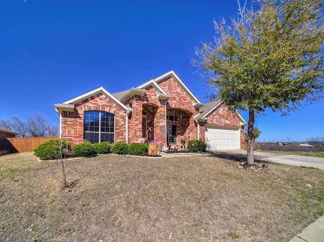 view of front of house with brick siding, an attached garage, fence, a front yard, and driveway