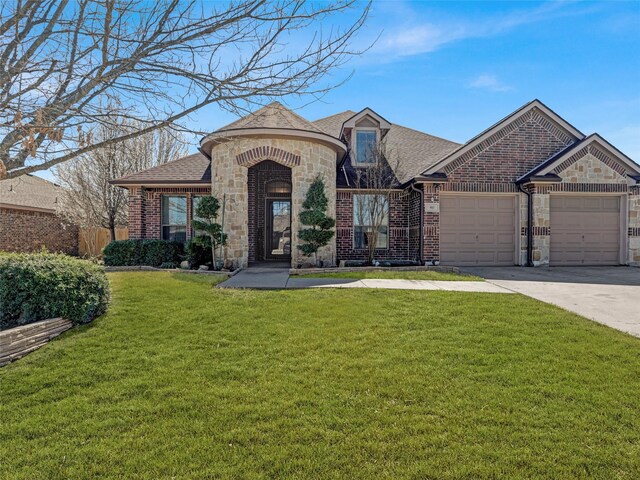 french country style house featuring driveway, a front lawn, a shingled roof, a garage, and brick siding