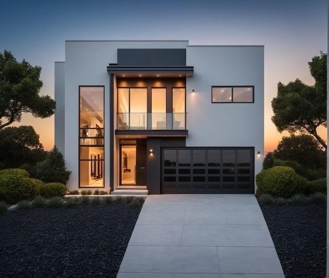 contemporary house with stucco siding, a balcony, a garage, and driveway