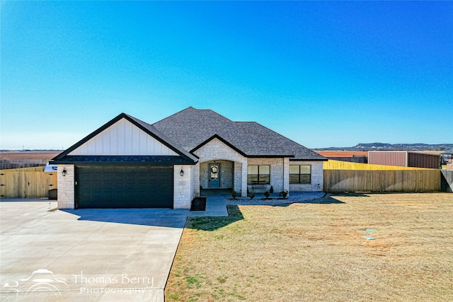 view of front of home featuring a front yard, fence, a garage, and driveway