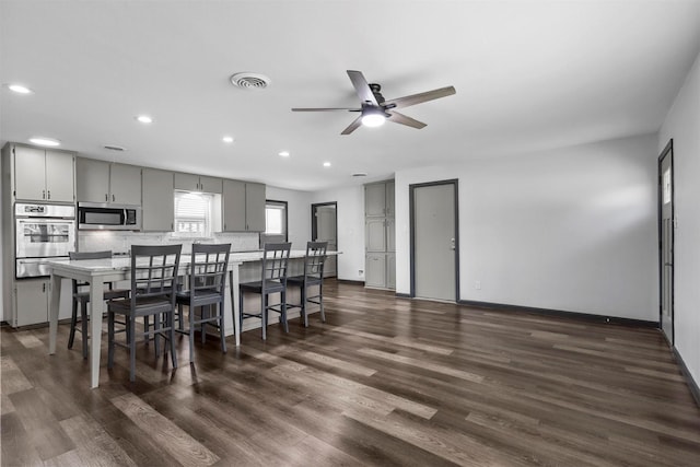 dining space featuring recessed lighting, ceiling fan, dark wood-style flooring, and baseboards