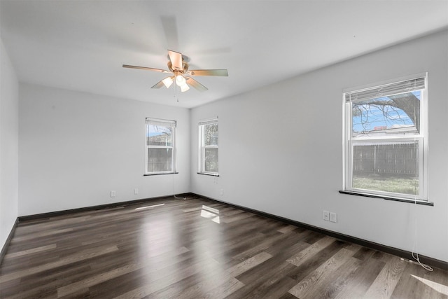 spare room featuring plenty of natural light, a ceiling fan, wood finished floors, and baseboards