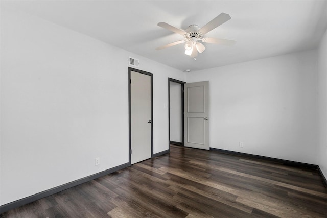 unfurnished bedroom featuring dark wood-type flooring, baseboards, and a ceiling fan