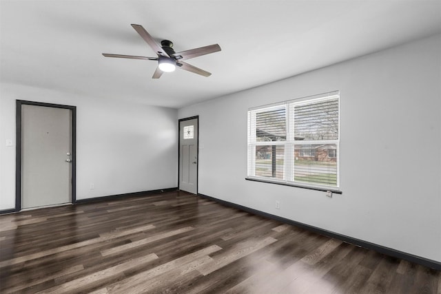 empty room featuring dark wood finished floors, ceiling fan, and baseboards