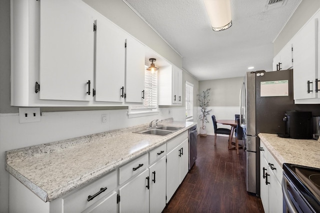 kitchen featuring a wainscoted wall, white cabinetry, dark wood-style flooring, a sink, and dishwasher