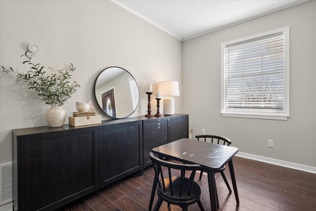 dining area with dark wood finished floors, crown molding, baseboards, and a textured ceiling