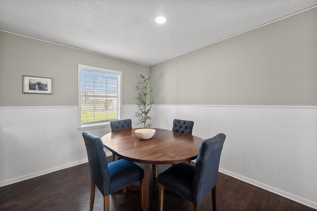 dining room with wainscoting, a textured ceiling, and wood finished floors