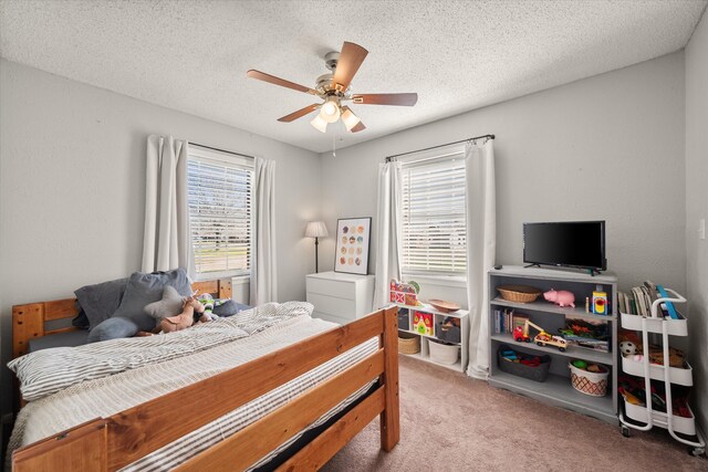 bedroom with carpet flooring, a ceiling fan, and a textured ceiling