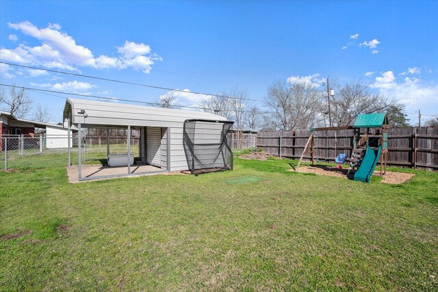 view of yard with a detached carport, a playground, a fenced backyard, and an outdoor structure