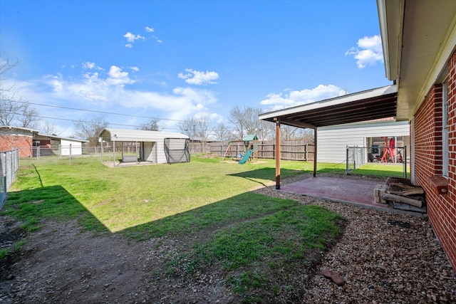 view of yard featuring a patio area, a playground, and a fenced backyard