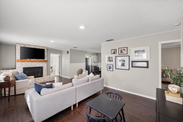 living room featuring visible vents, baseboards, a brick fireplace, and dark wood-style floors