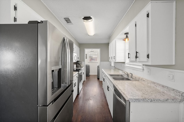 kitchen with a sink, stainless steel appliances, and white cabinets