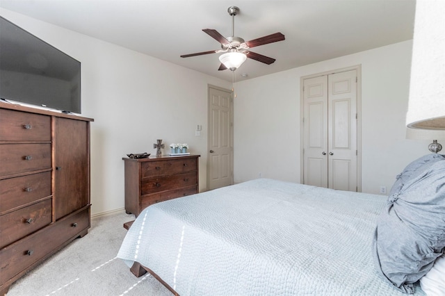 bedroom featuring a closet, light colored carpet, and ceiling fan