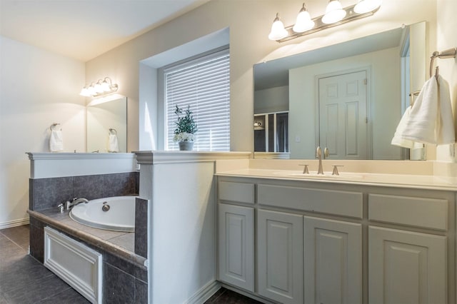 bathroom with tile patterned flooring, vanity, and a garden tub