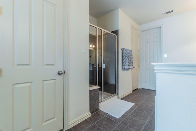 bathroom with tile patterned floors, visible vents, a shower stall, and baseboards