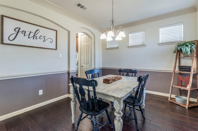 dining area featuring hardwood / wood-style flooring, crown molding, visible vents, and arched walkways