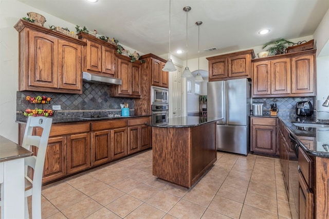 kitchen featuring visible vents, under cabinet range hood, a sink, appliances with stainless steel finishes, and light tile patterned floors