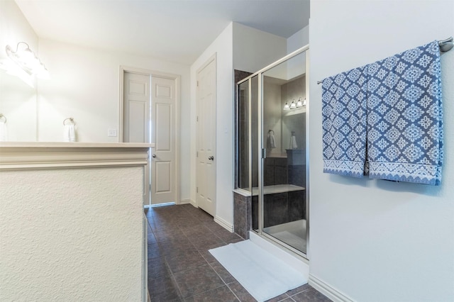 full bathroom featuring tile patterned floors, a shower stall, and baseboards